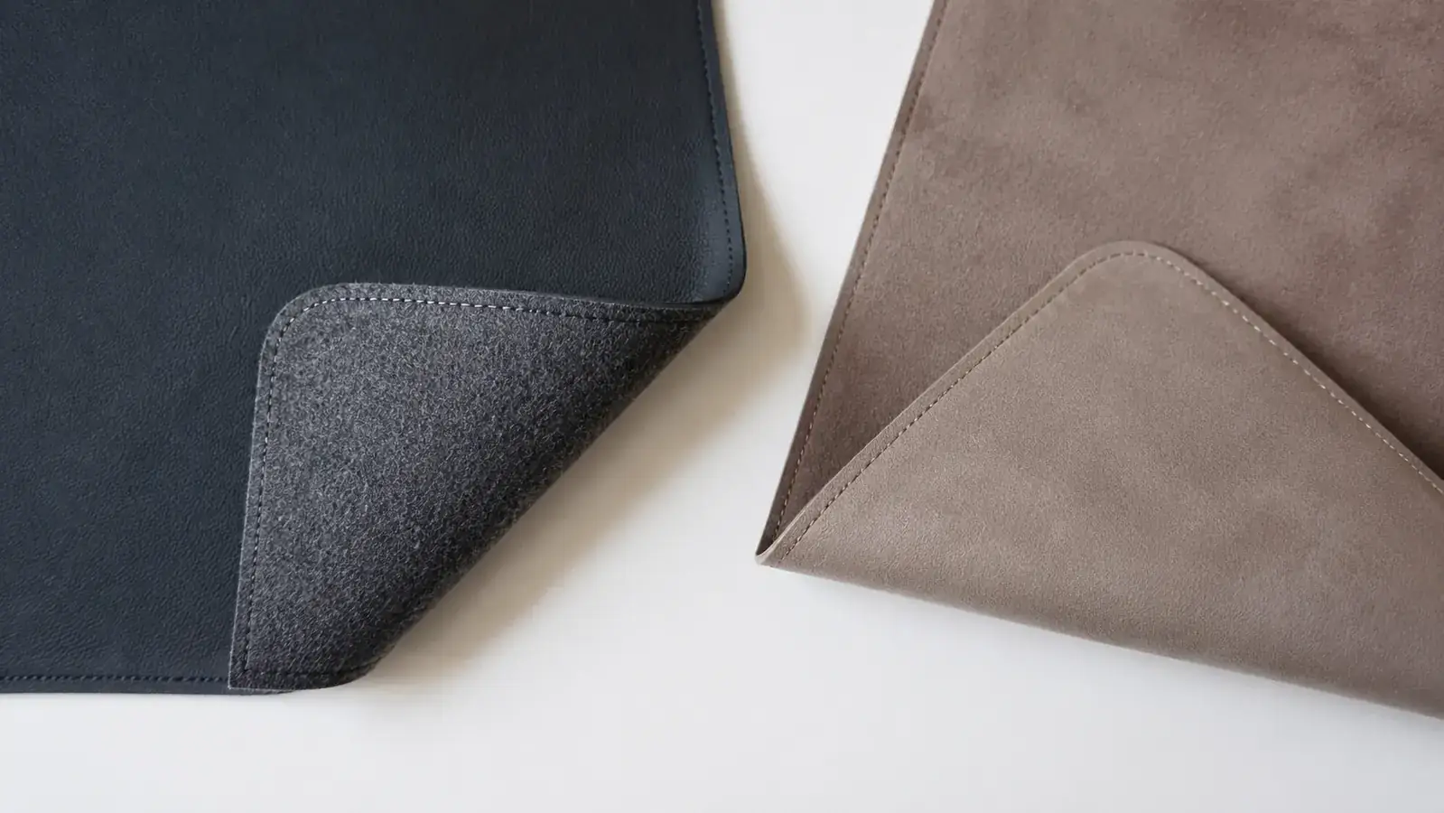 Underside of a desk pad showing non-slip rubber or felt backing texture compared to a competitor's smoother backing
