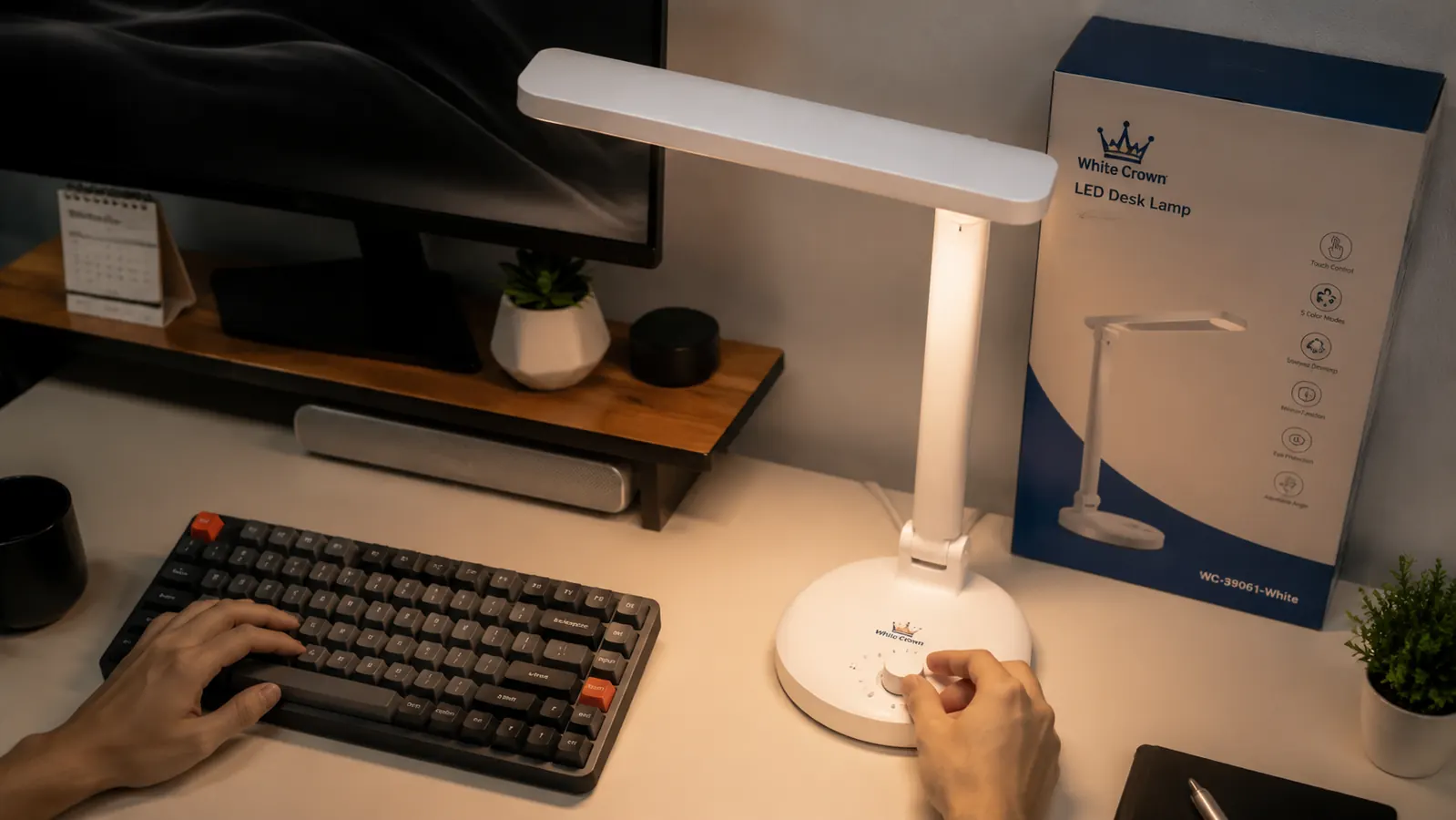 White Crown LED desk lamp on a home office desk next to a keyboard and notebook